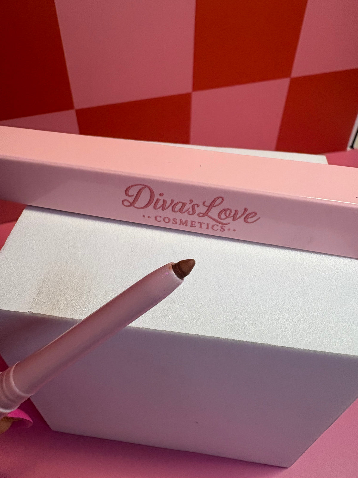 Diva's Love Cosmetics nude taupe lip liner with pink packaging on pink checkered background
